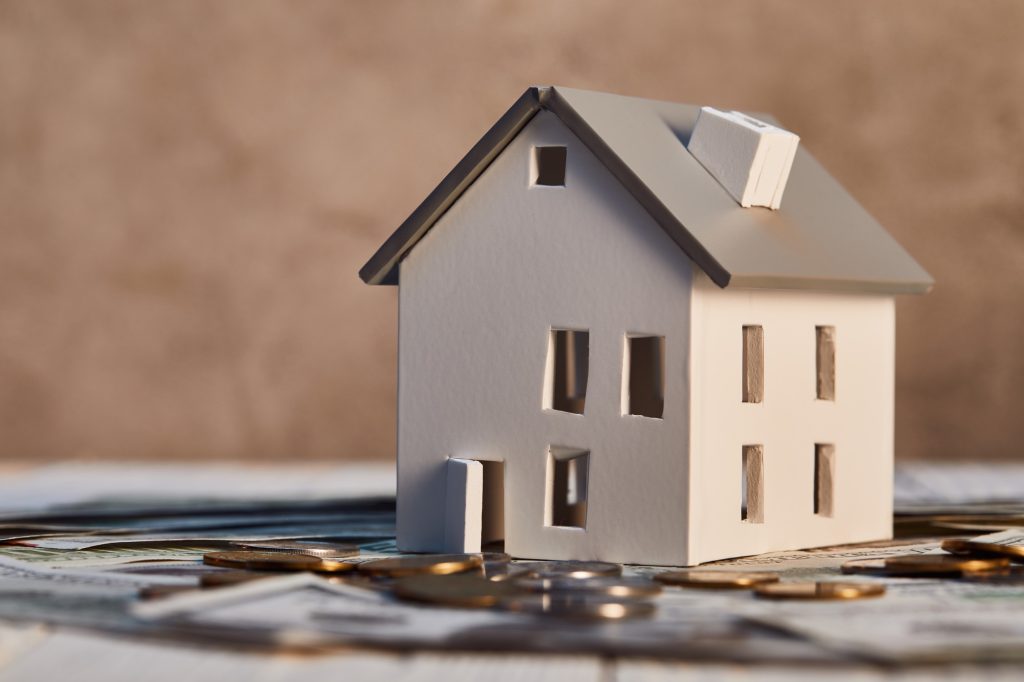 house model on dollar banknotes and coins, real estate concept